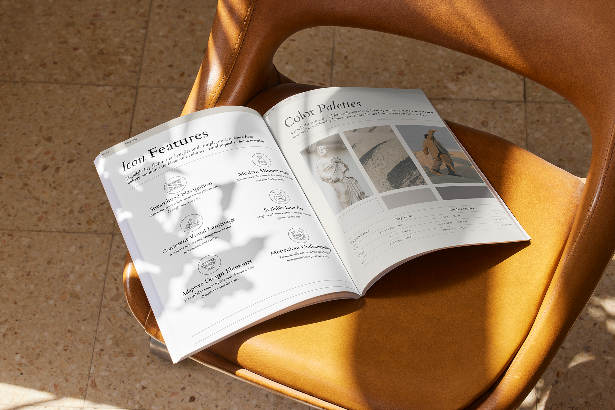 Open magazine on a tan leather chair with a shadow of a plant casting over the pages. The visible page features sections titled 'Icon Features' and 'Color Palettes' with icons and images of sculptures, dunes, a person walking, and swatches of color.