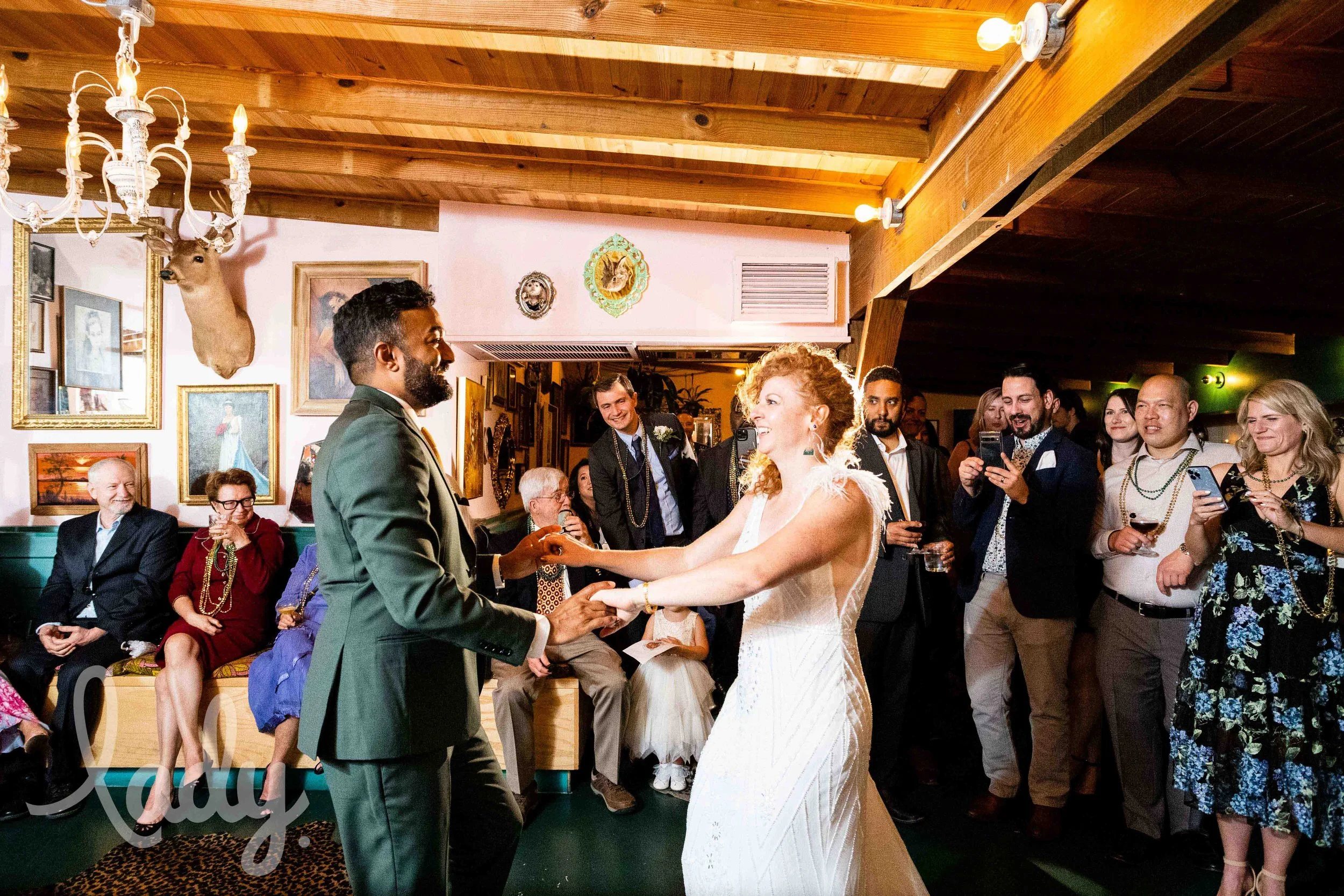 A bride and groom share their first dance while friends and family watch inside of Mr. Mao in New Orleans.