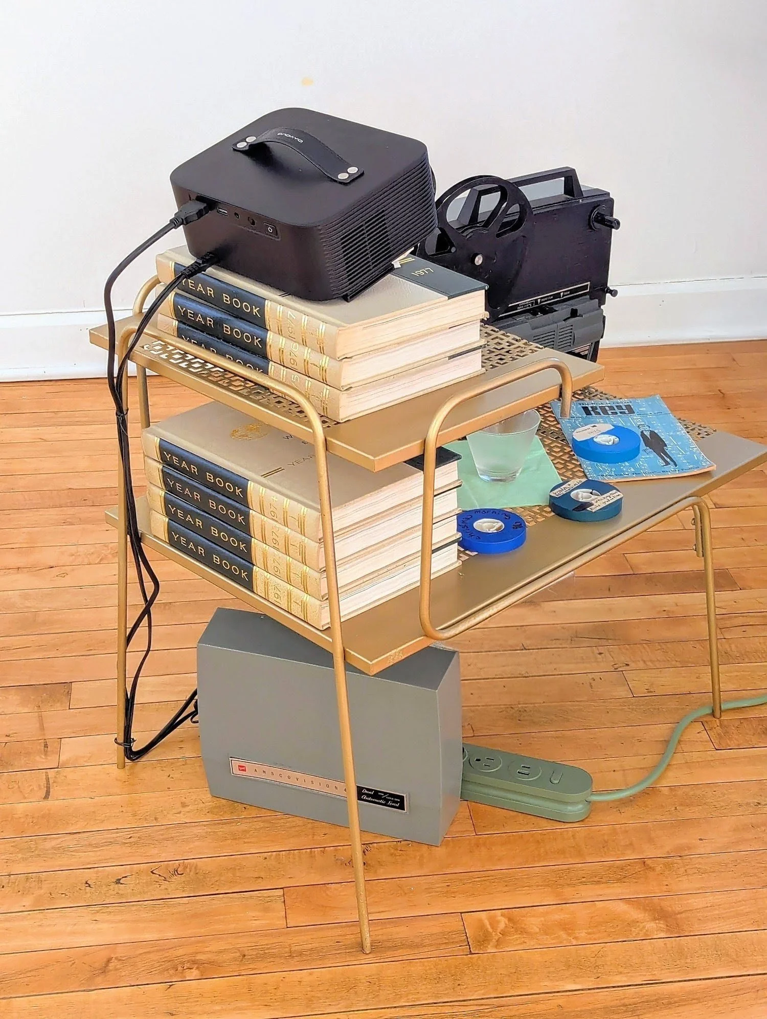  SUPER-8 1977  2026. Mid-century side table, original Hellstrom Family Kodak Home-Movie kit with projector and screen, WORLD BOOK ENCYCLOEPDIA YEAR BOOKS 1971-1977 (when Harlow and Hank left the planet within one month of each other) mid-century punc