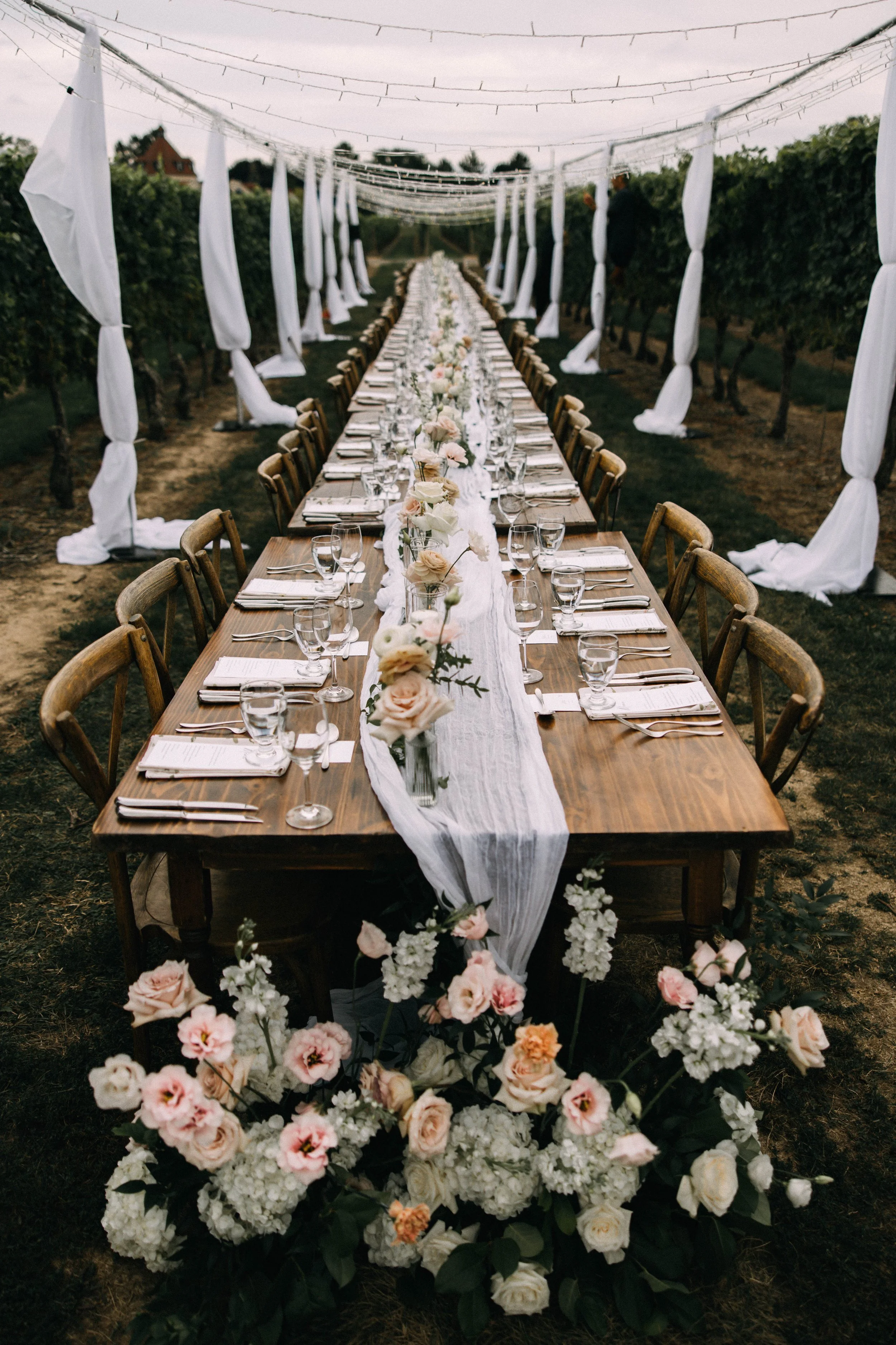 Harvest table  under a canopy of twinkle lights in the vineyard for this alfresco dinner at Konzelmann Winery.
  Photo by Young Glass Photography