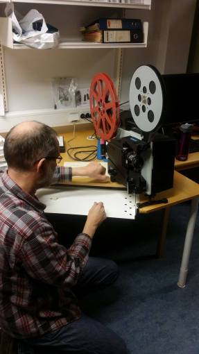 Musikkarkivar Ivar Mogstad tørker støv av 16mm filmframviseren av merket Elmo