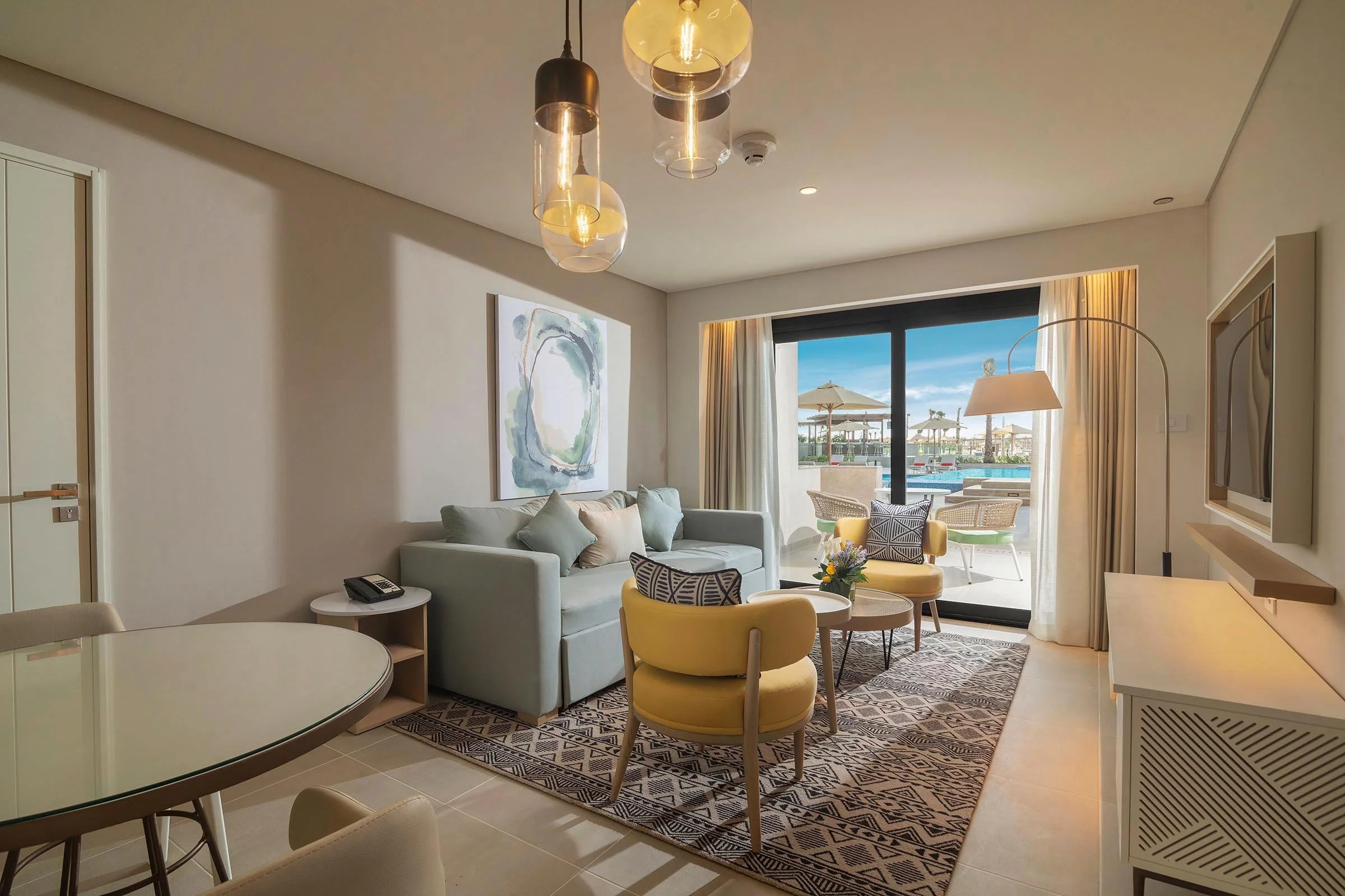 Living area with sofa and seating overlooking terrace and pool at Palma Bay Rotana Resort.jpg