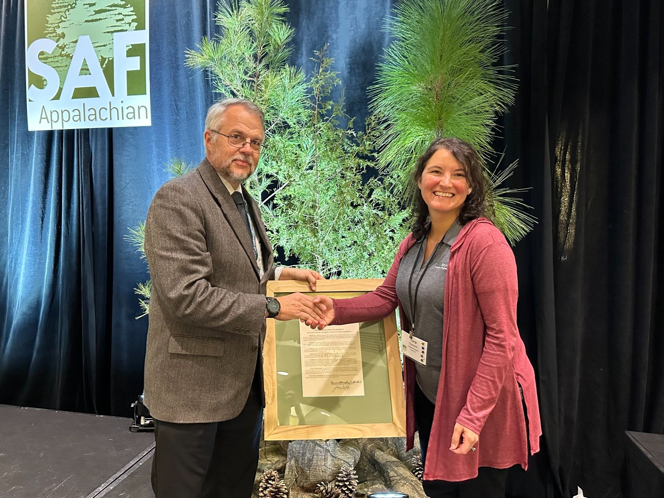 Ed Zimmer, 2023 APSAF Chair, presenting Tara Dickson, 2023 NC Past Chair, with a framed APSAF 100-Year Proclamation 