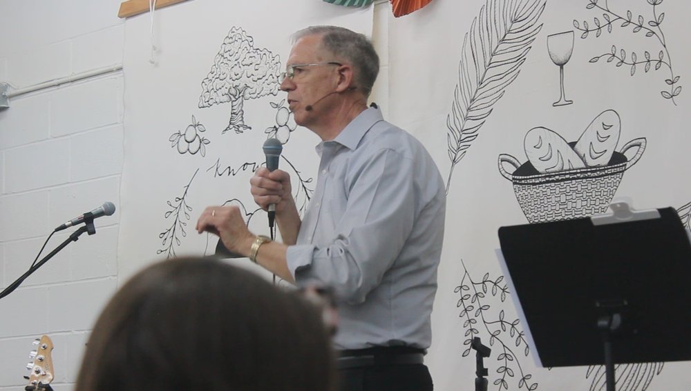 An elder teaching with a microphone