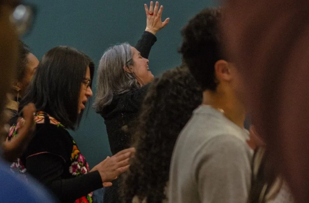 Church members worshiping together with hands raised