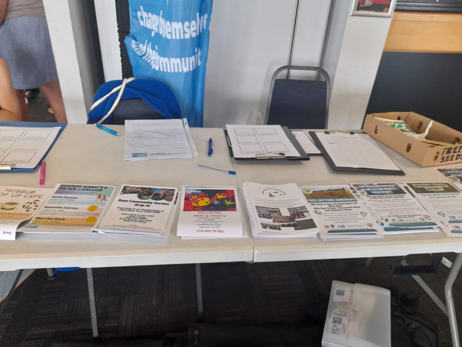 picture of a table set up with lots of leaflets. A flag behind reads 'The Hub Lockleaze'