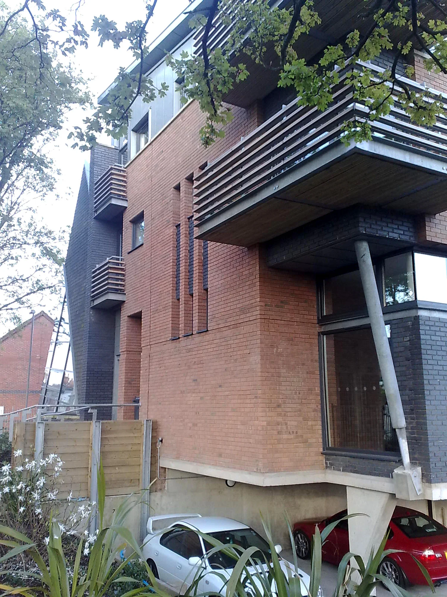 Heaton St - Newbuild - cantilevered balconies to 1st & 2nd floor apartments above Community centre to Ground floor level. Open, semi-basement parking below GFL