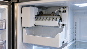 Empty ice bin inside open residential freezer compartment