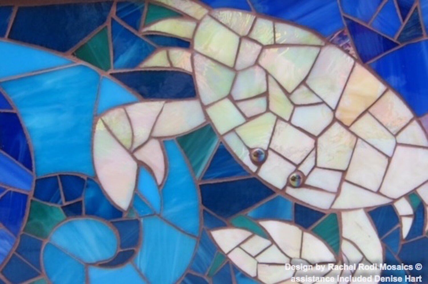 Close-up of mermaid-themed fireplace mosaic mural, glass