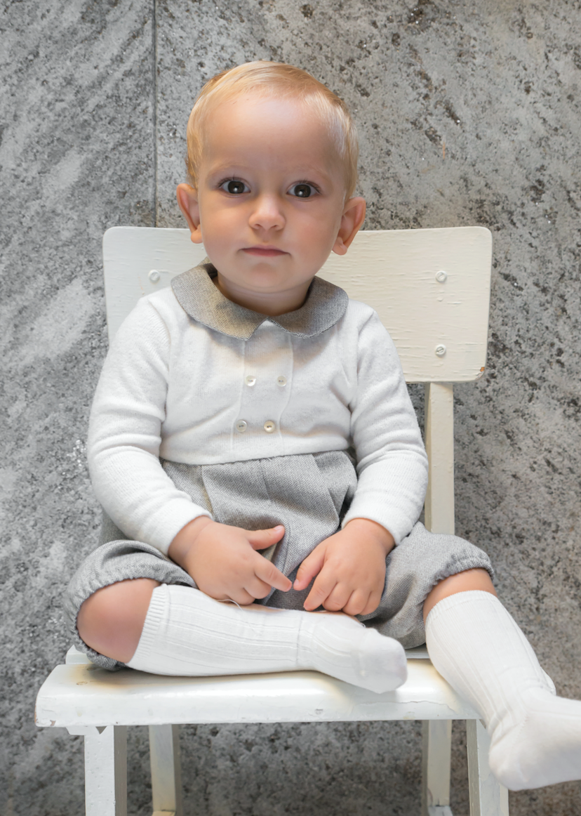 Pagliaccetto neonato in maglia panna e spigato grigio scuro indossato