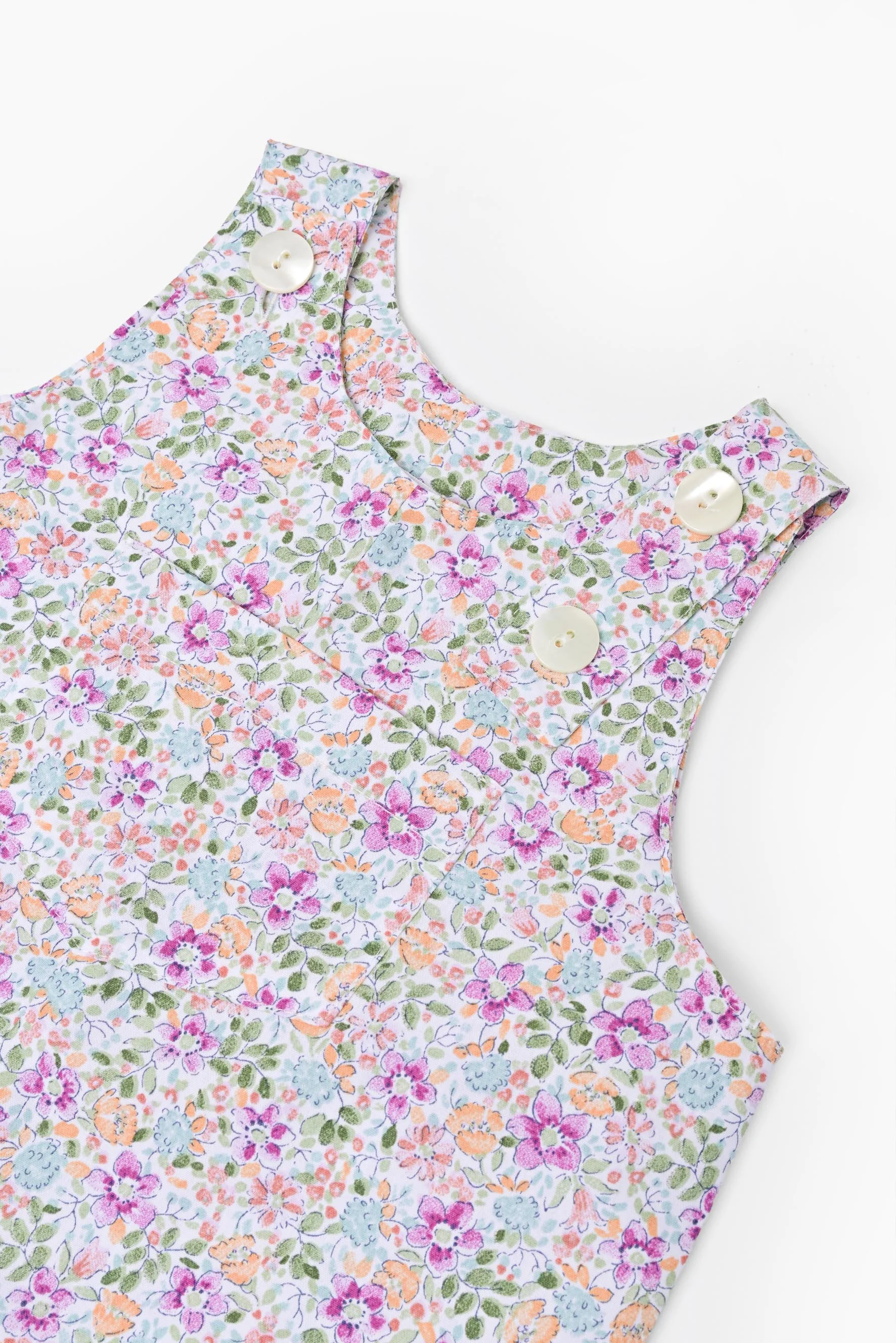 Salopette neonata fiore viola turchese dettaglio bretelle