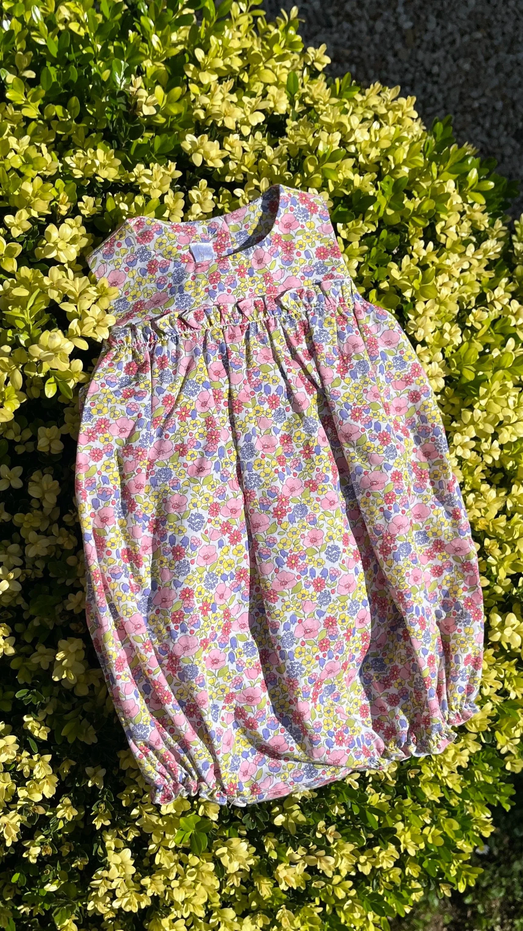 Pagliaccetto neonata in fresco cotone a fiori gialli, rosa e viola con piccola rouches nel davanti