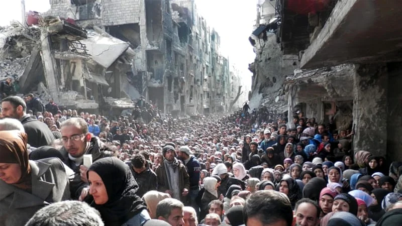 Residents of Yarmouk camp on the outskirts of Damascus queuing to receive food supplies when the camp was besieged. Syria 2014. Photo: UNRWA via AP