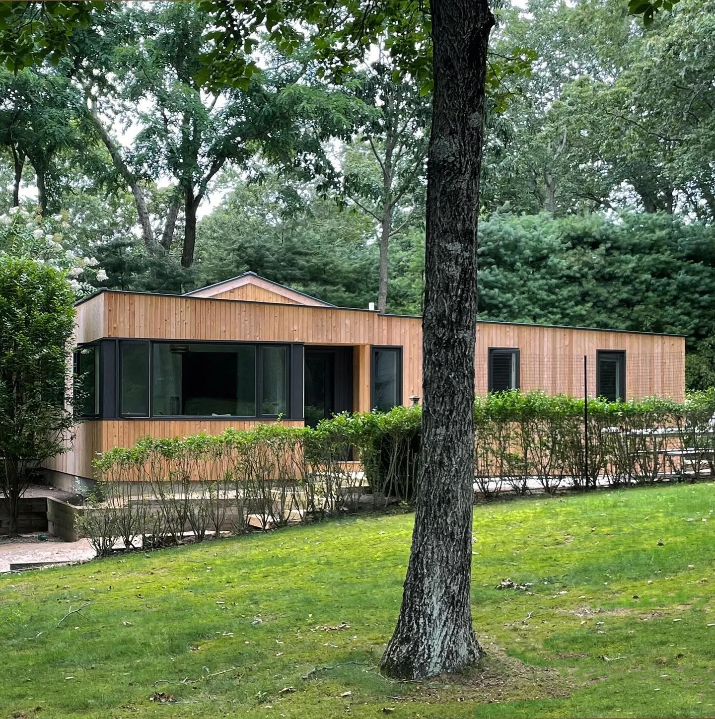 Thinking of summer and beach houses now. This addition was completed in 2023 in the town of Sag Harbor, NY. Vertical white cedar cladding on the exterior and painted vertical boards on the interior give it a bright and an informal feel. #reidarchitec