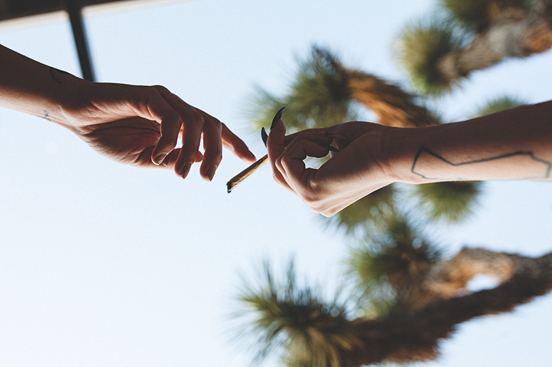 Model hands pictured passing a joint between each other.