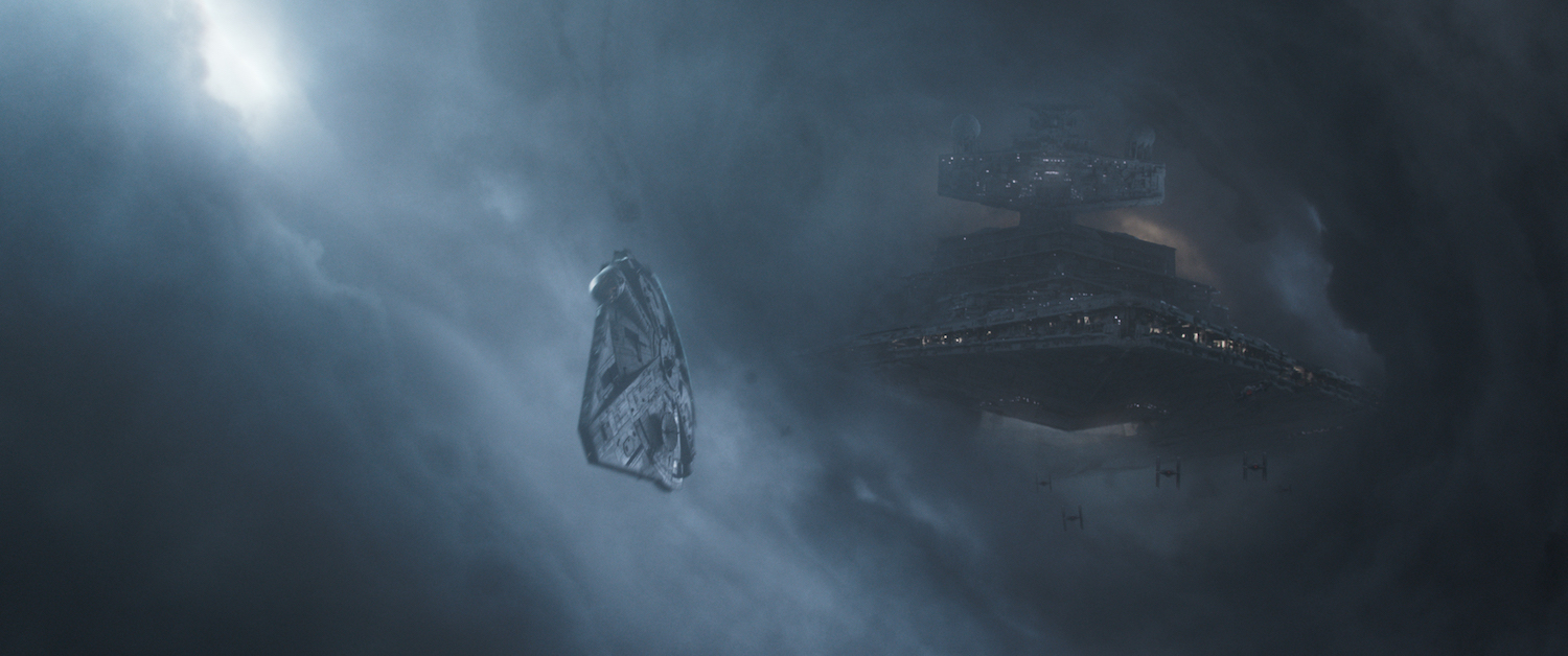 The Millennium Falcon veering away from an Imperial starship along the famed “Kessel run” in Solo: A Star Wars Story