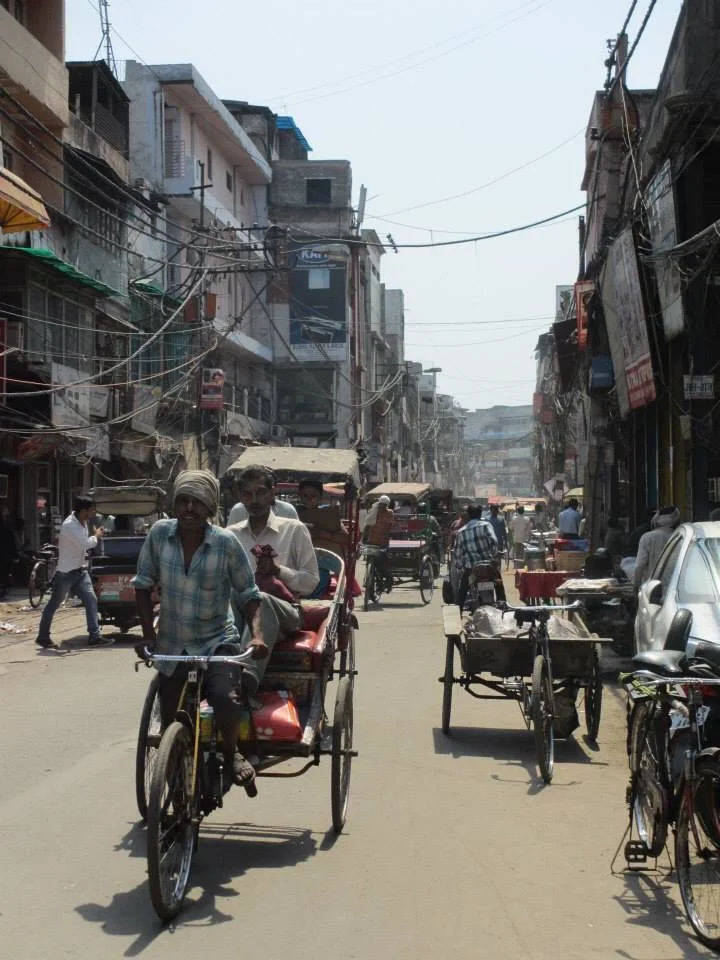 An old fashioned rickshaw on a typically busy street in Old Dehli.