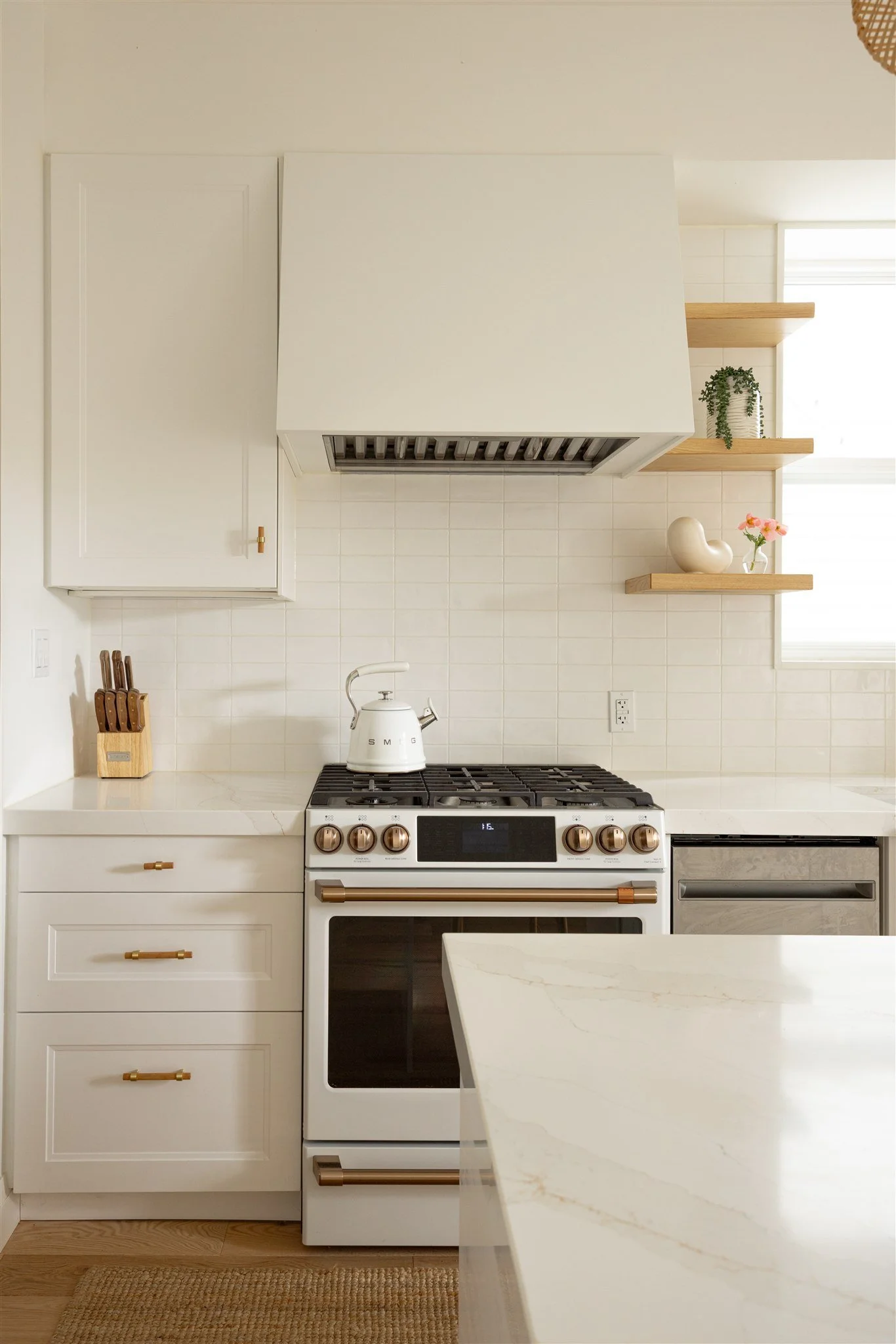 white kitchen with brass accents and floating shleves