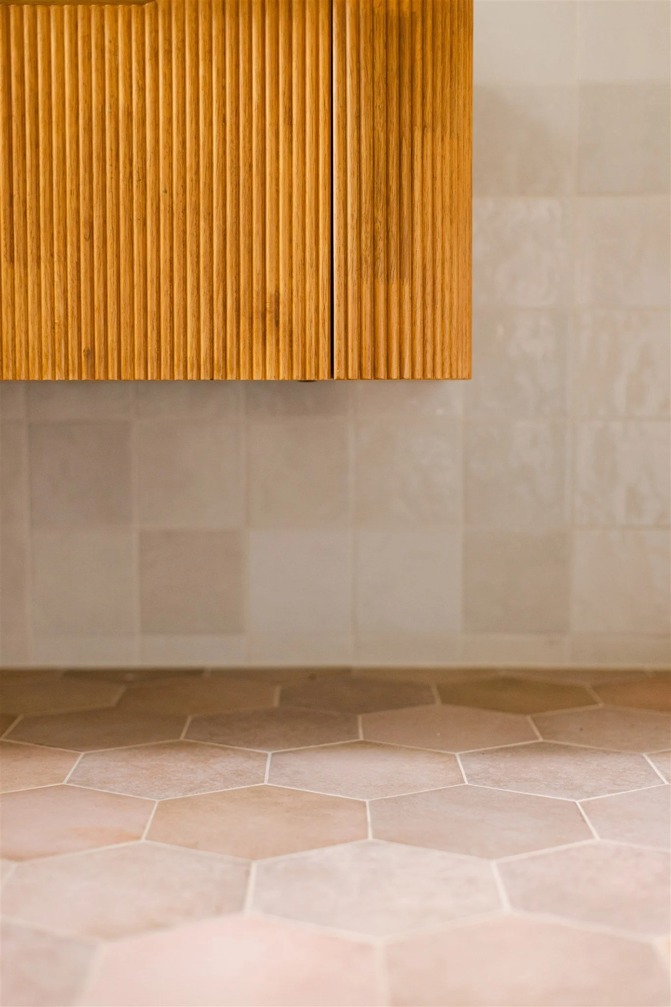 detail of pink and white tiles with floating vanity.