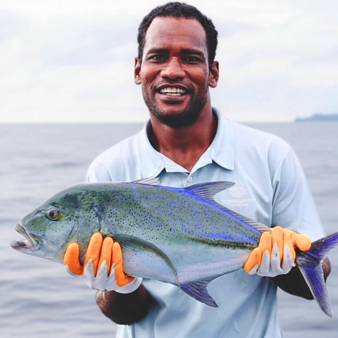 Boat Captain and Tour guide Roni holding a Blue Fin Trevally (which he then releases)