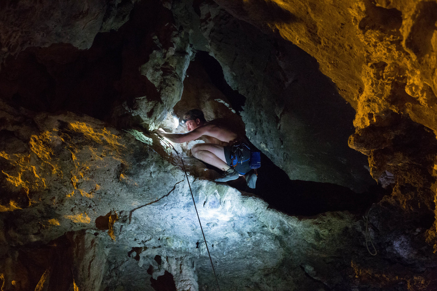 Climbers use headlamps to guide their way across narrow ledges and caves after sundown on Tonsai Beach in Thailand. March 2017. 