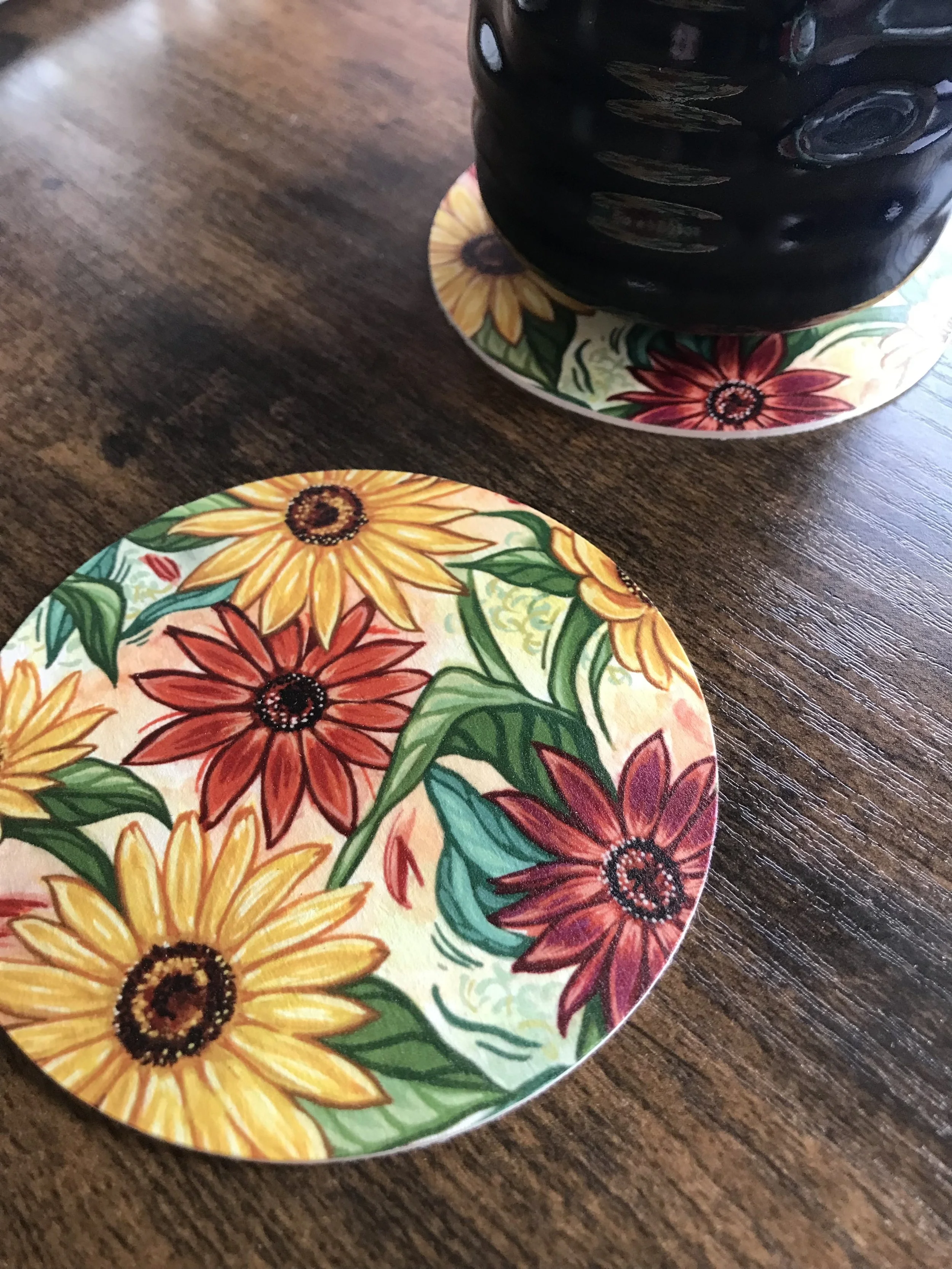 Fall coaster with a sunflower painting on a wooden background
