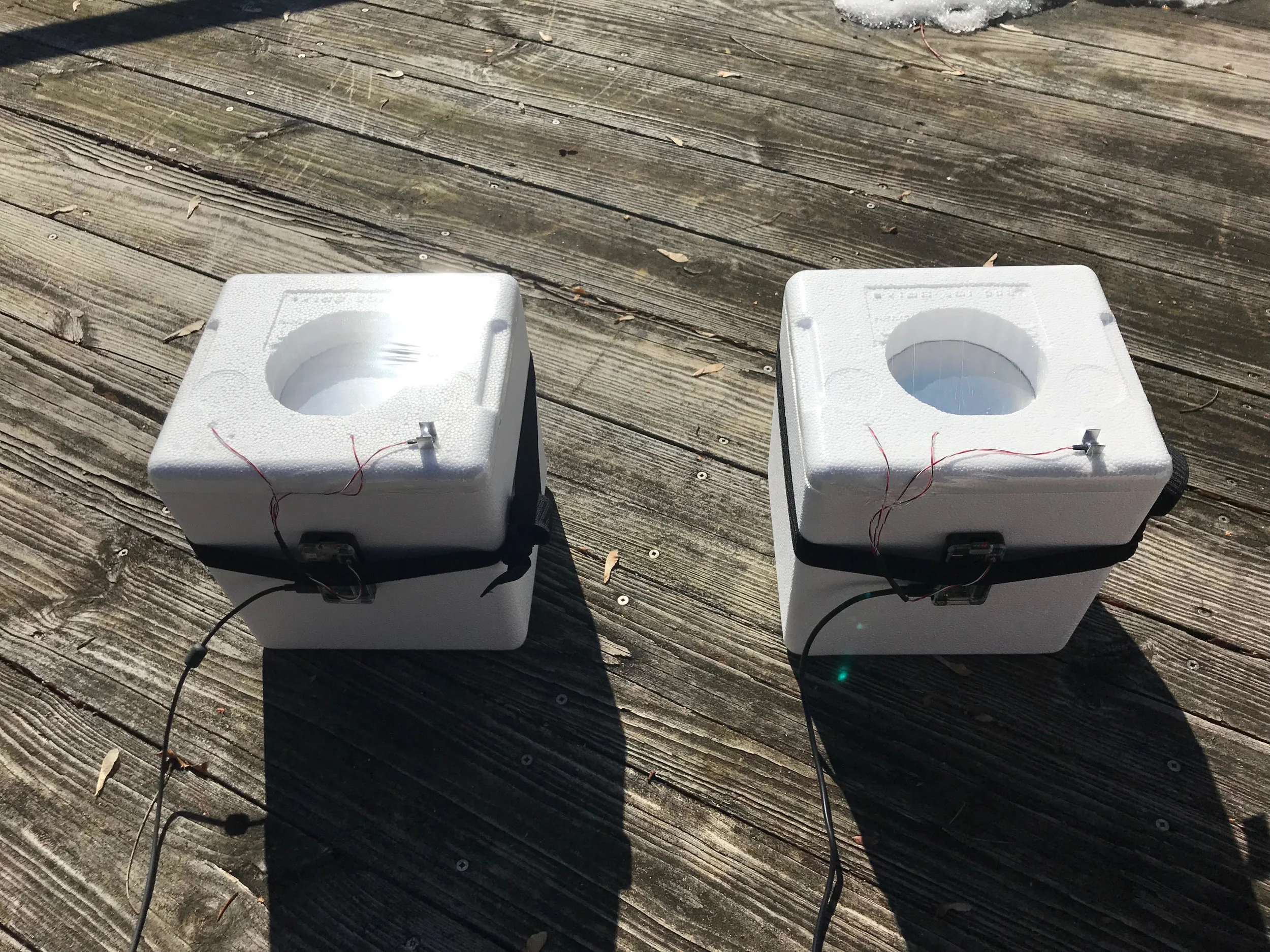 This is our testing setup. It is sending us data right now . One cube has a simplified version of our cooling material. The other cube does not. Click on the link below to see real-time temperature data .