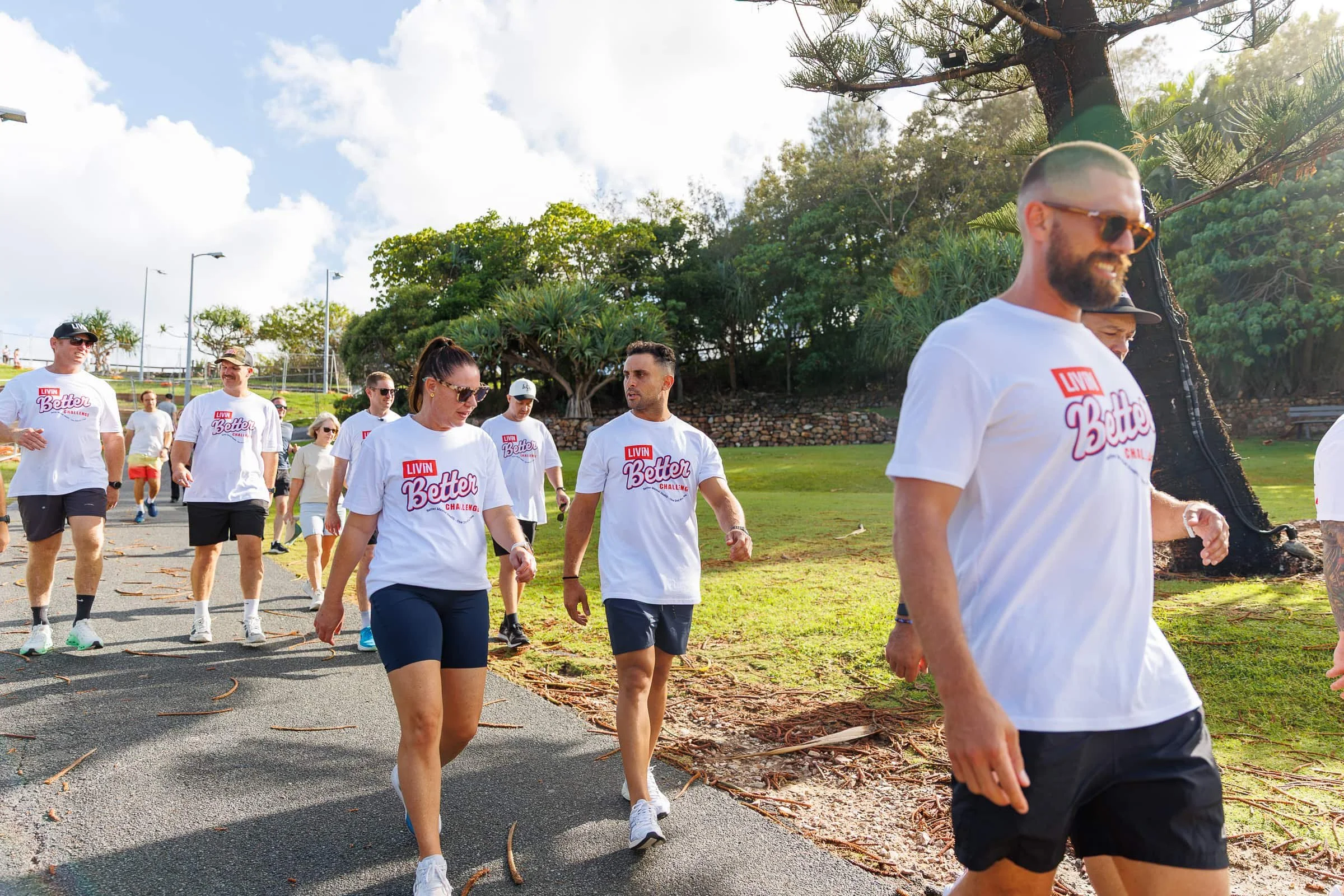 Group of a dozen people walking wearing white t-shirts. Text reads LIVIN Better Challenge