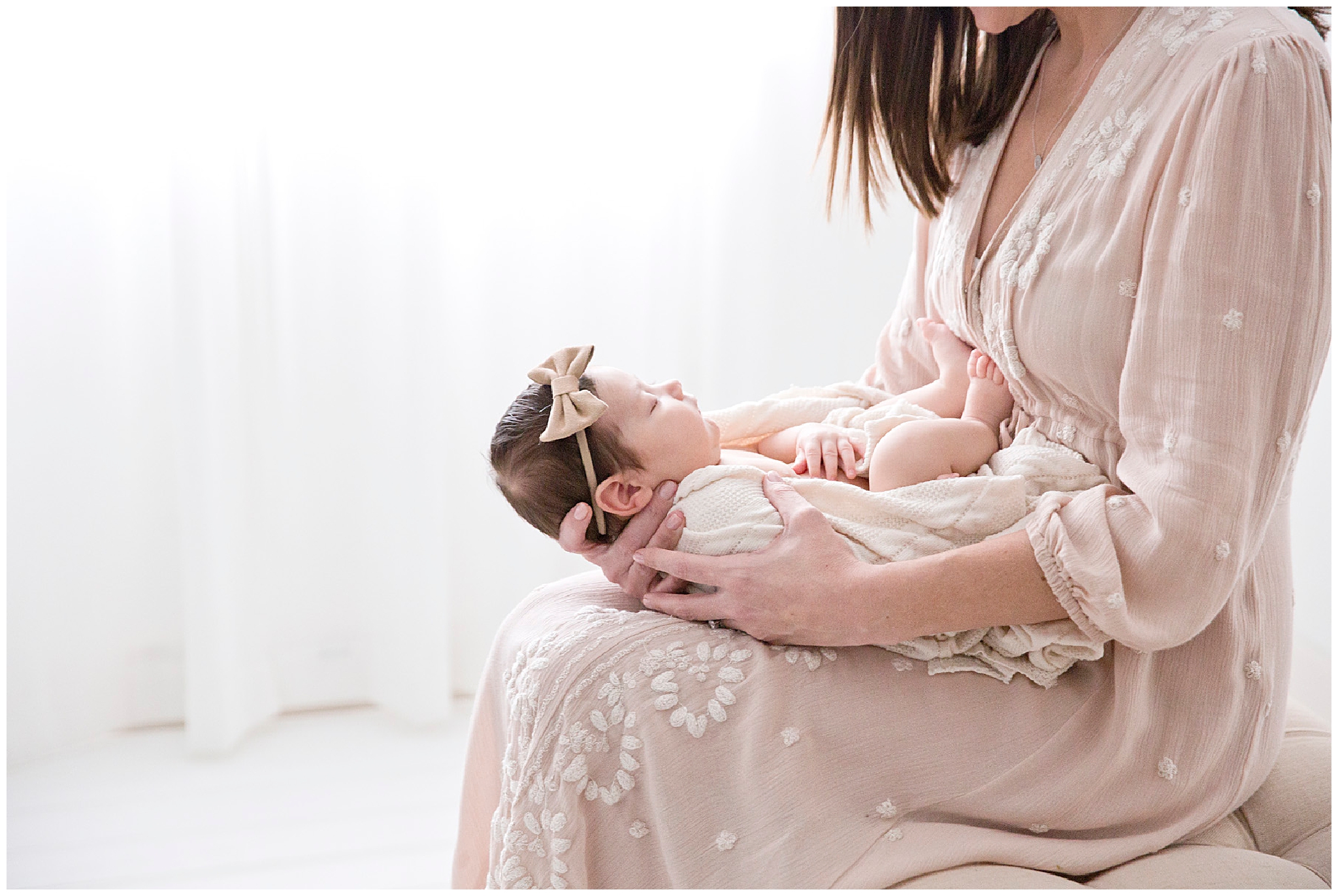 Mom holding newborn girl during her newborn session in Miami FL by Ready Freddie Studios