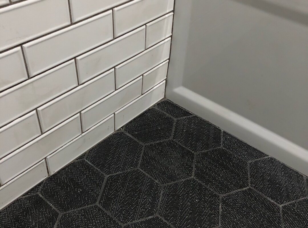 Bathroom white beveled subway tile with heagen black floor_queens apartment.jpg