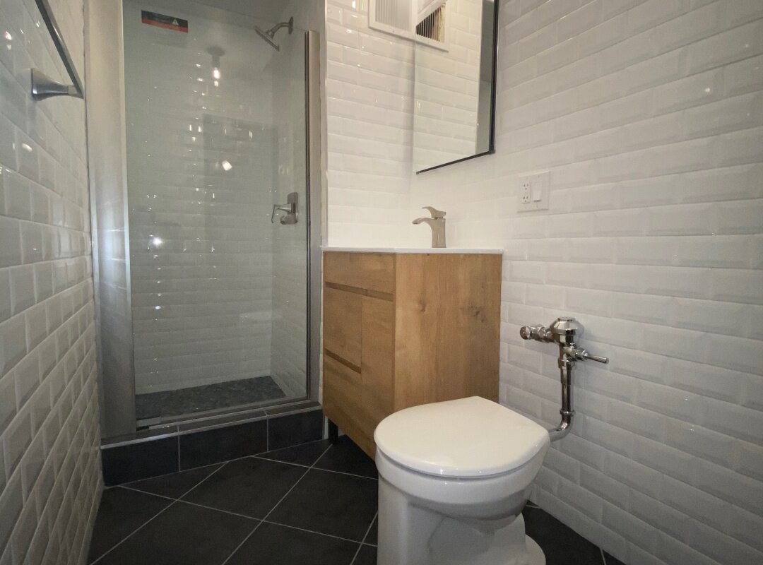 Bathroom white beveled subway tile with wood cabinet_queens apartment.jpg