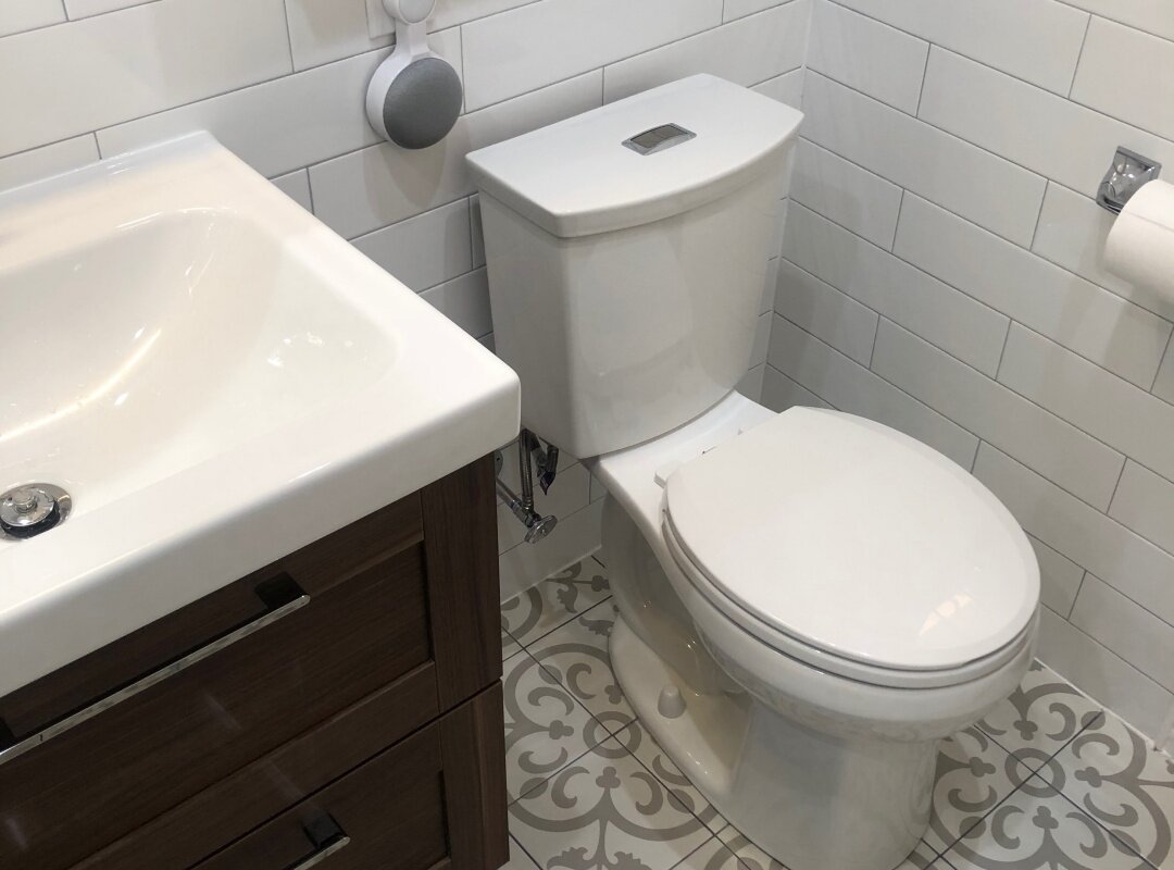 Bathroom white subway tiles with cement floor motif_queens apartment.jpg