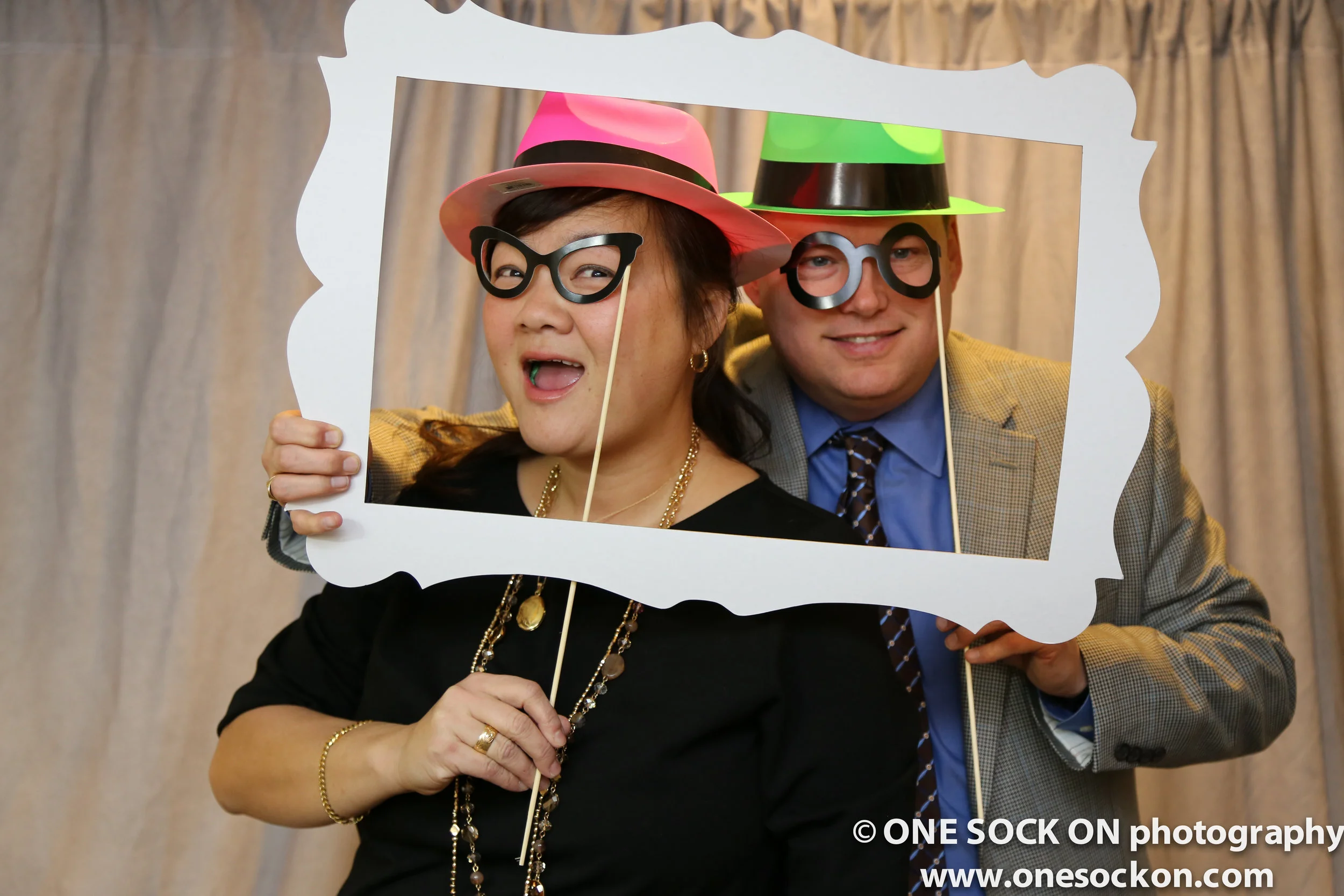 photobooth at party colored hat frame happy couple