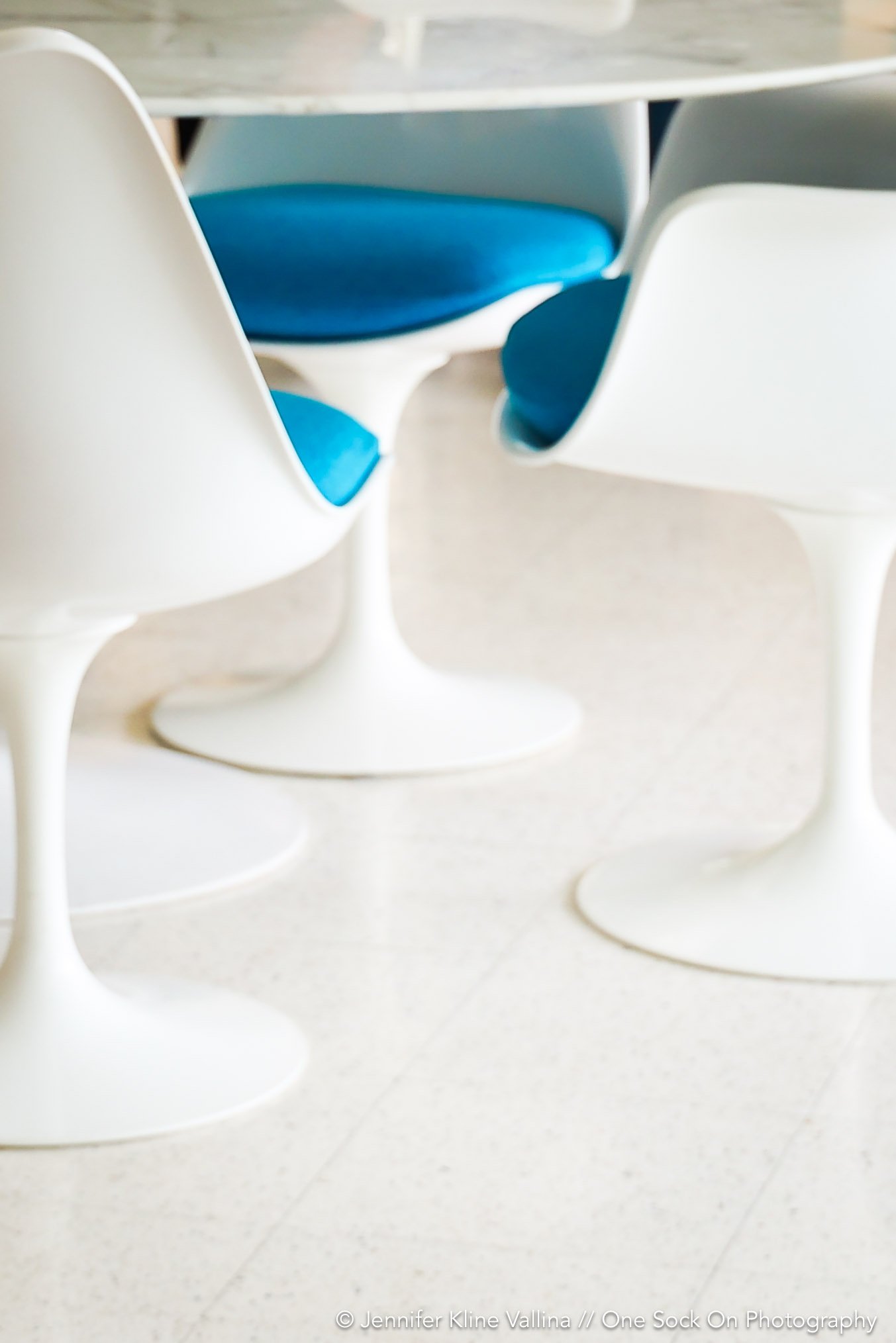 modern style white chairs blue seat cushions around a tulip table midcentury modern modernism week palm springs interior design