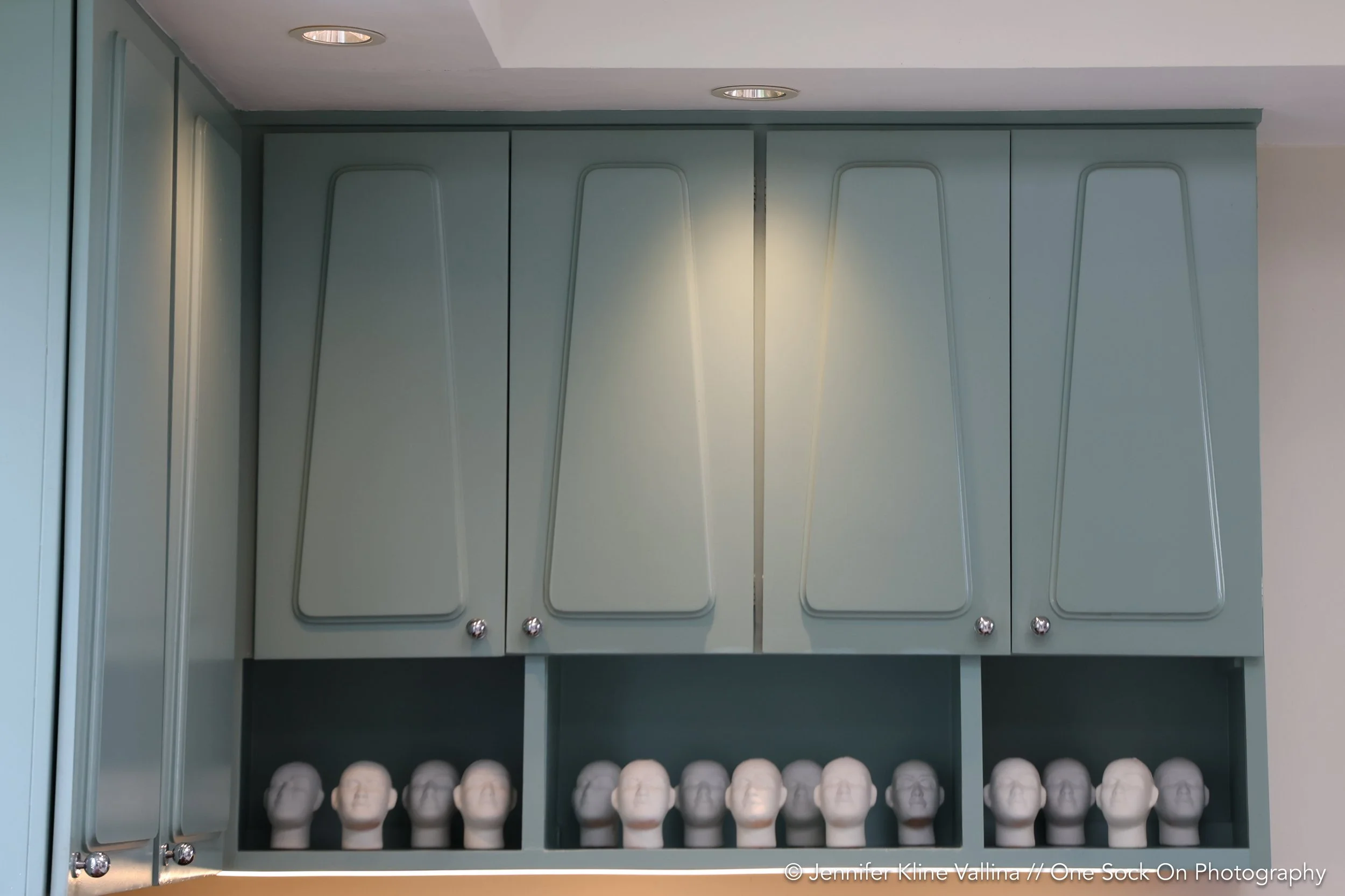 light teal kitchen cabinets with decorative heads 
