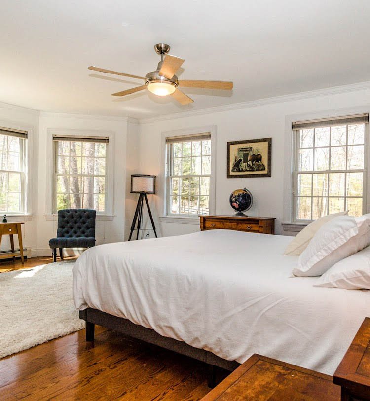 A bright bedroom with a large bed, white bedding by Charlie Hoffman Photography Narrowsburg NY.jpg