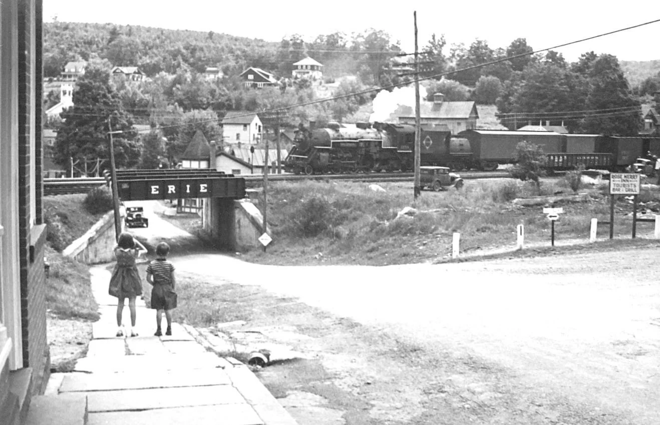 All aboard for a trip back to 1940 🚂⁠ This photo captures a train crossing the Erie RR overpass through Narrowsburg, looking toward Lake Erie. ⁠
At right, a sign points to the Rose Merry Inn (aka the Commodore Murray House) on 5th Street &mdash; and