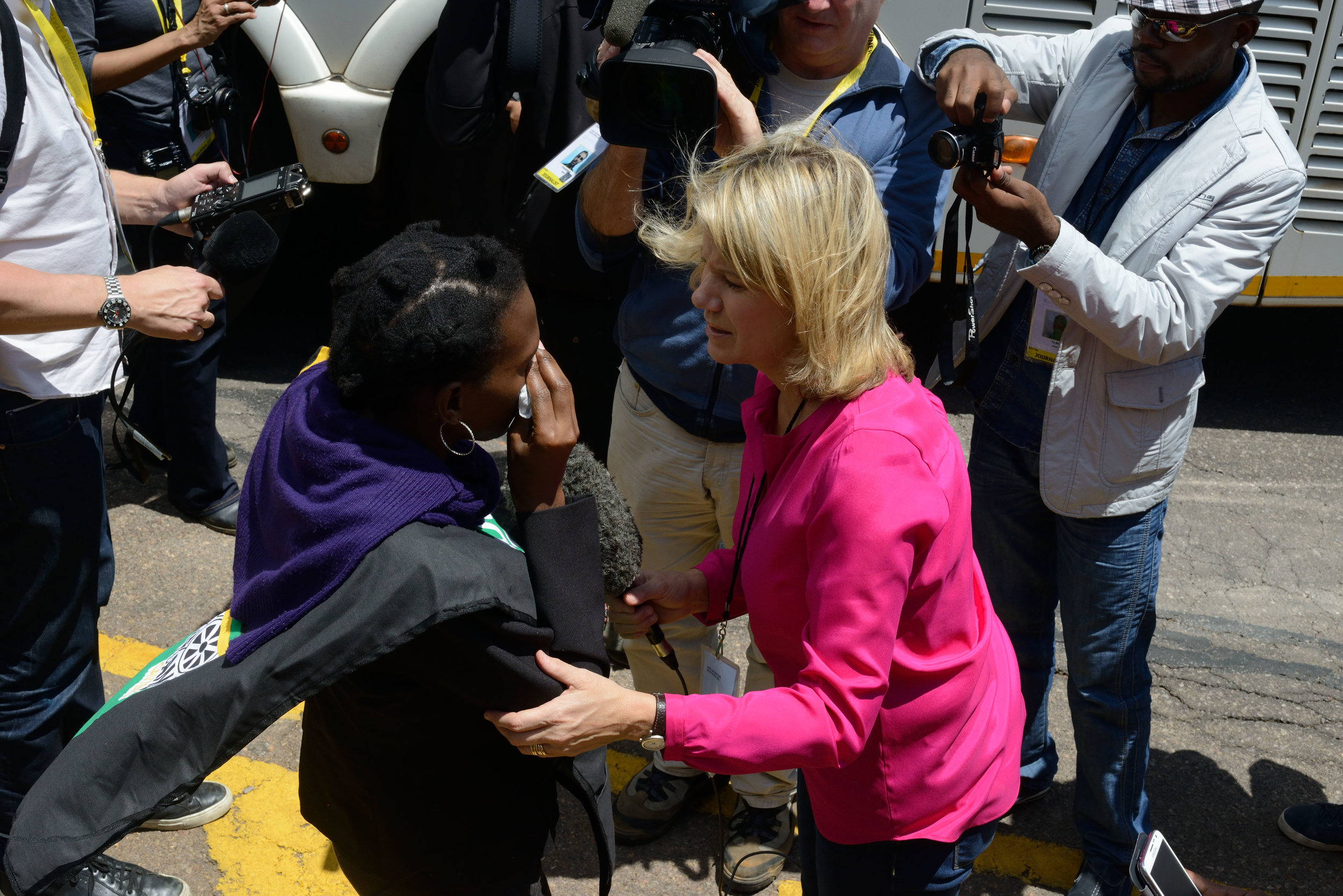 An anchorwoman interviewing a mourner who has just viewed the body of Nelson Mandela lying in state, Pretoria, South Africa