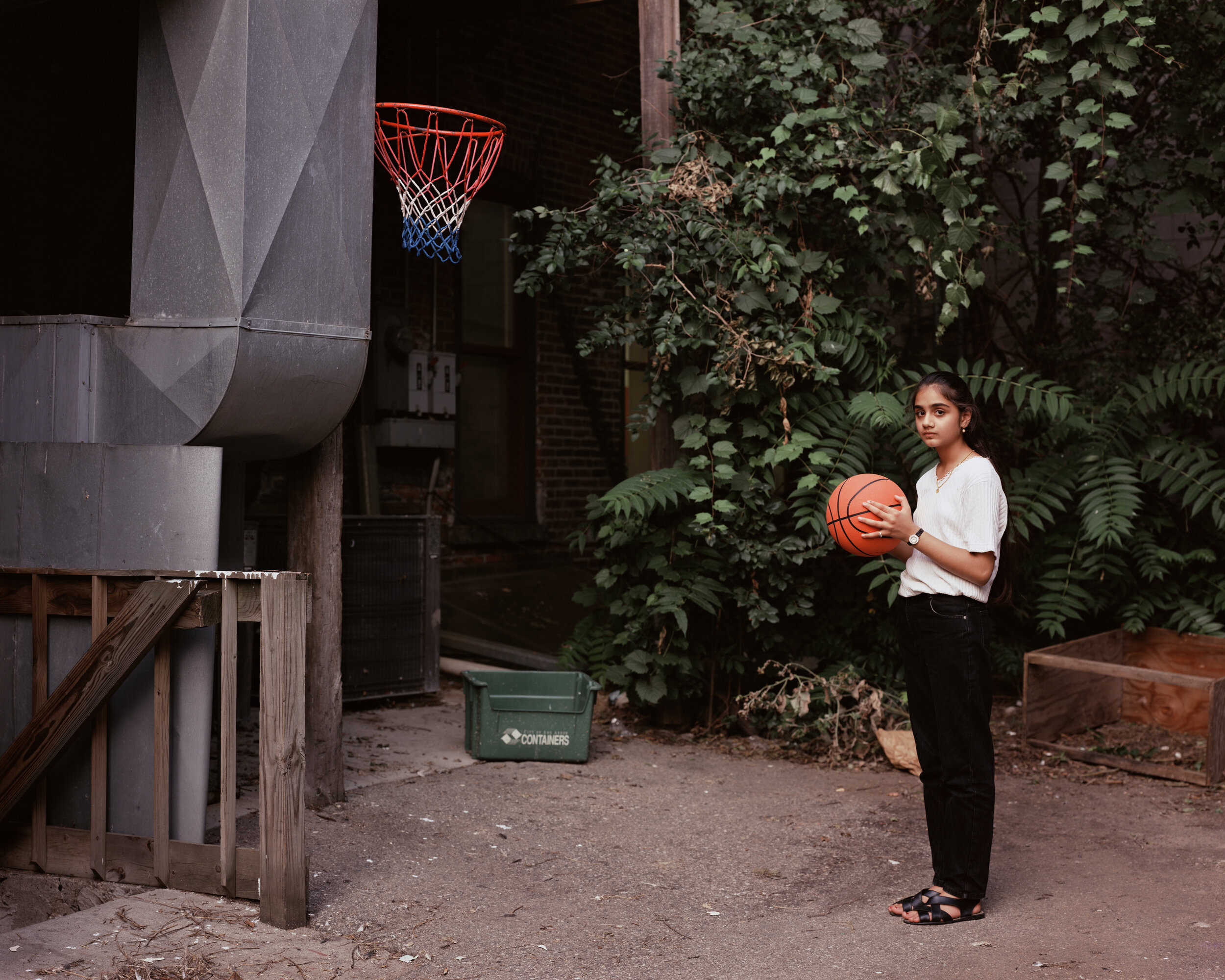 A young woman playing basketball behind her father's restaurant, Ann Arbor, Michigan 1995