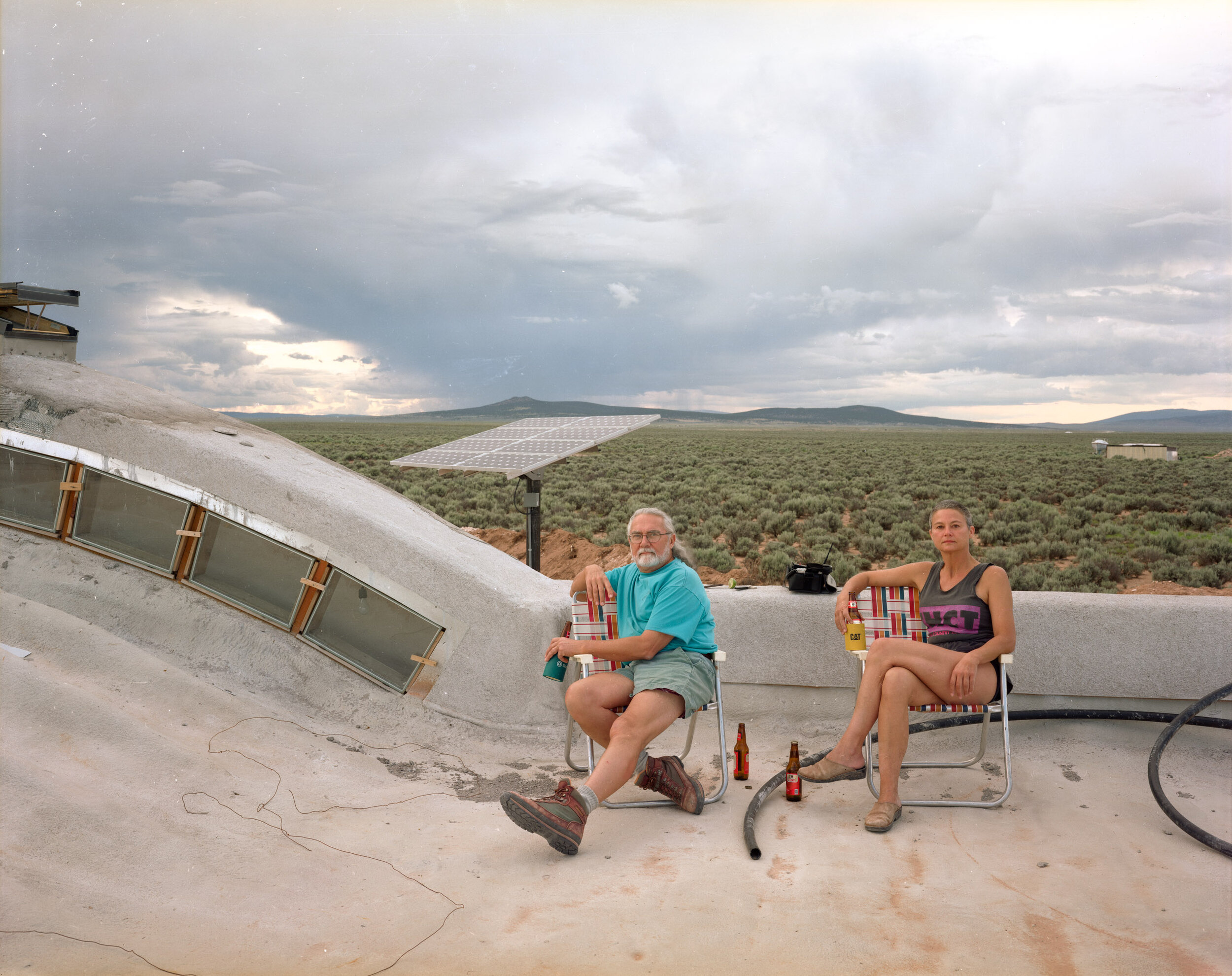 A Couple on the Roof of Their Home under Construction, Tres Orejas, New Mexico, July 1999