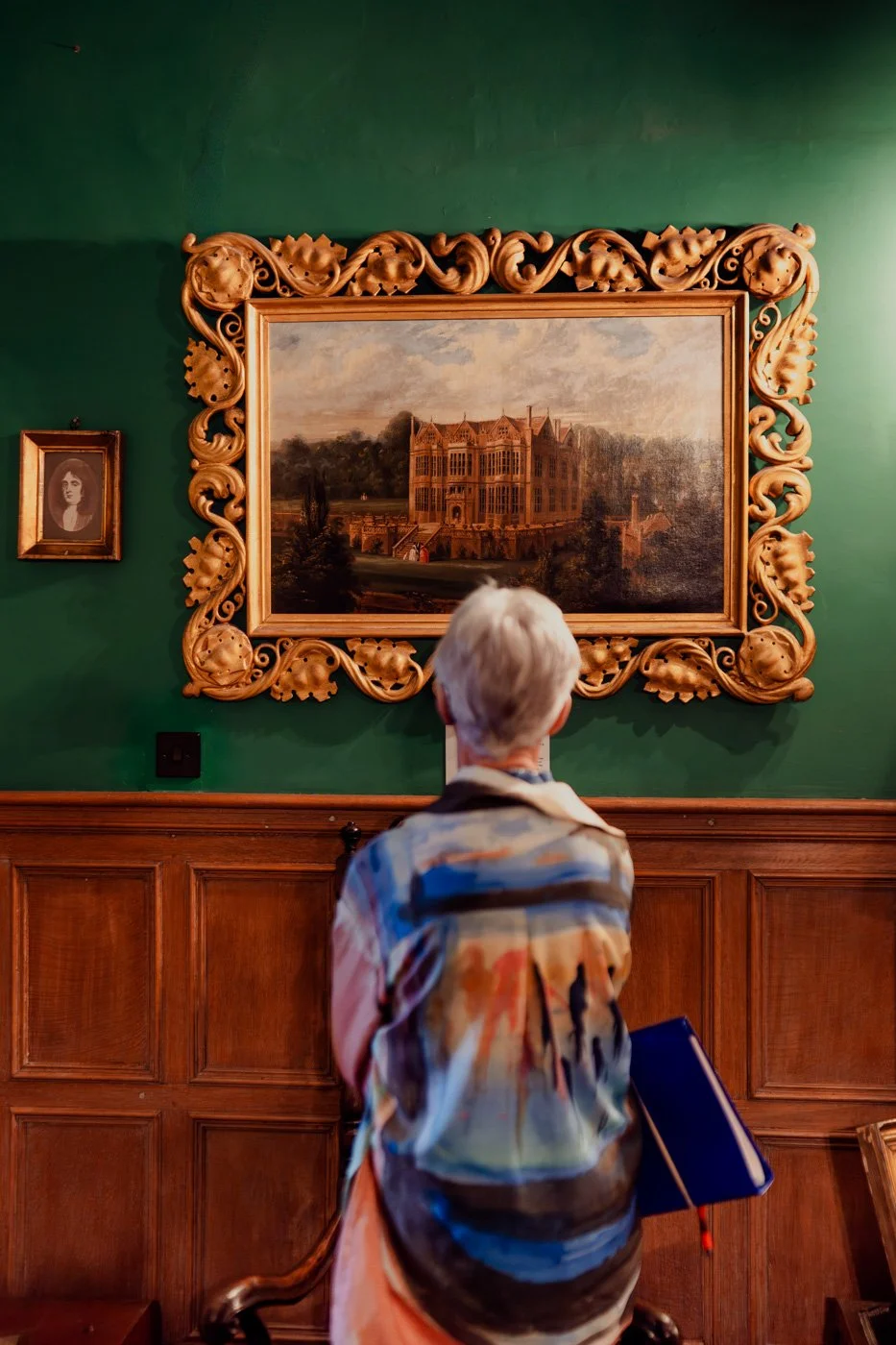 Miniature bicycle display inside a glass dome, placed on a table in a cozy, vintage-style room.