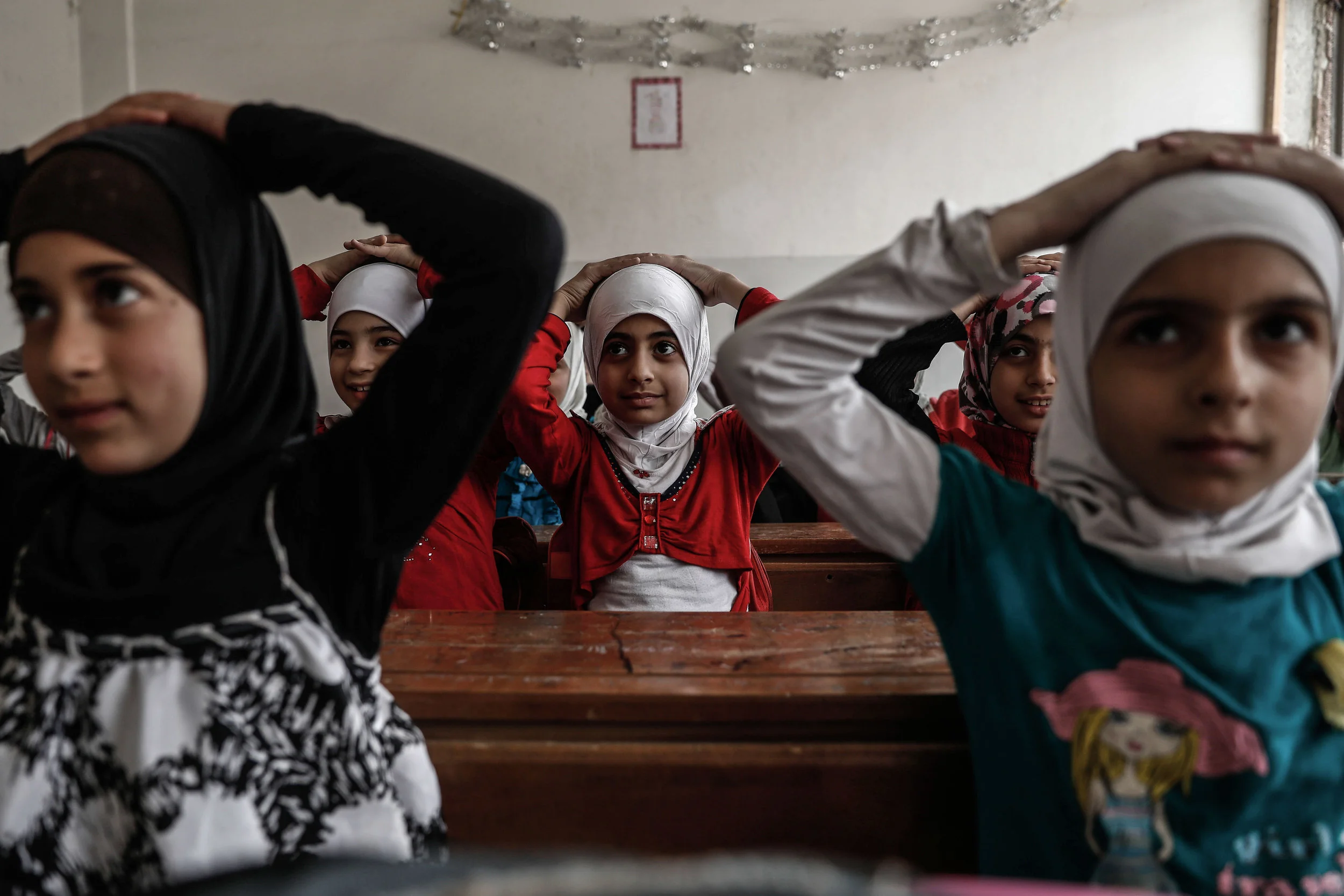 Schoolchildren learn how to protect themselves in case of a bombardment during a war safety awareness class as part of a campaign conducted by the Syrian civil defence, known as The White Helmets