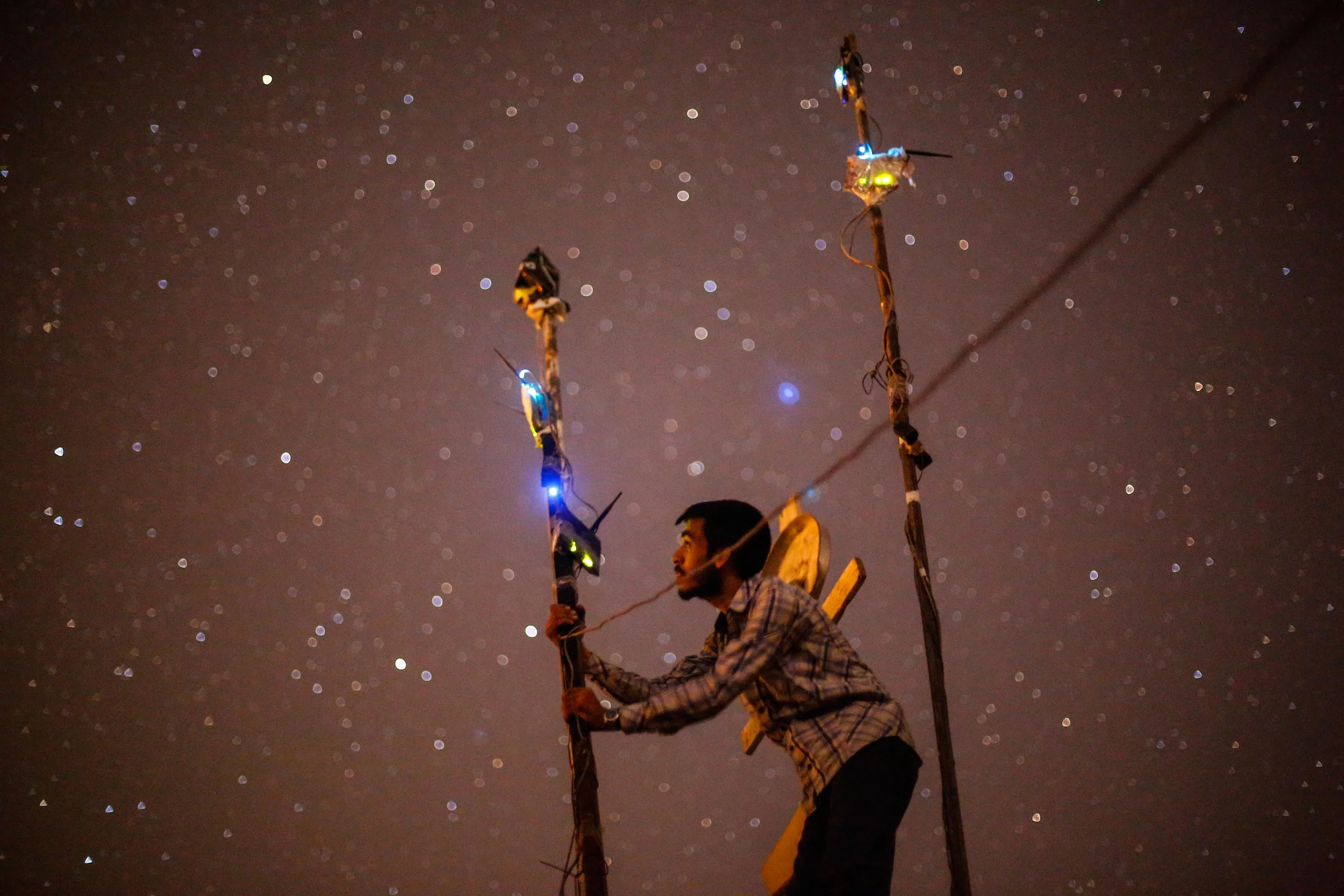 A man puts the internet Modem at a high altitude in order to try to get some signal from nearby regime areas.