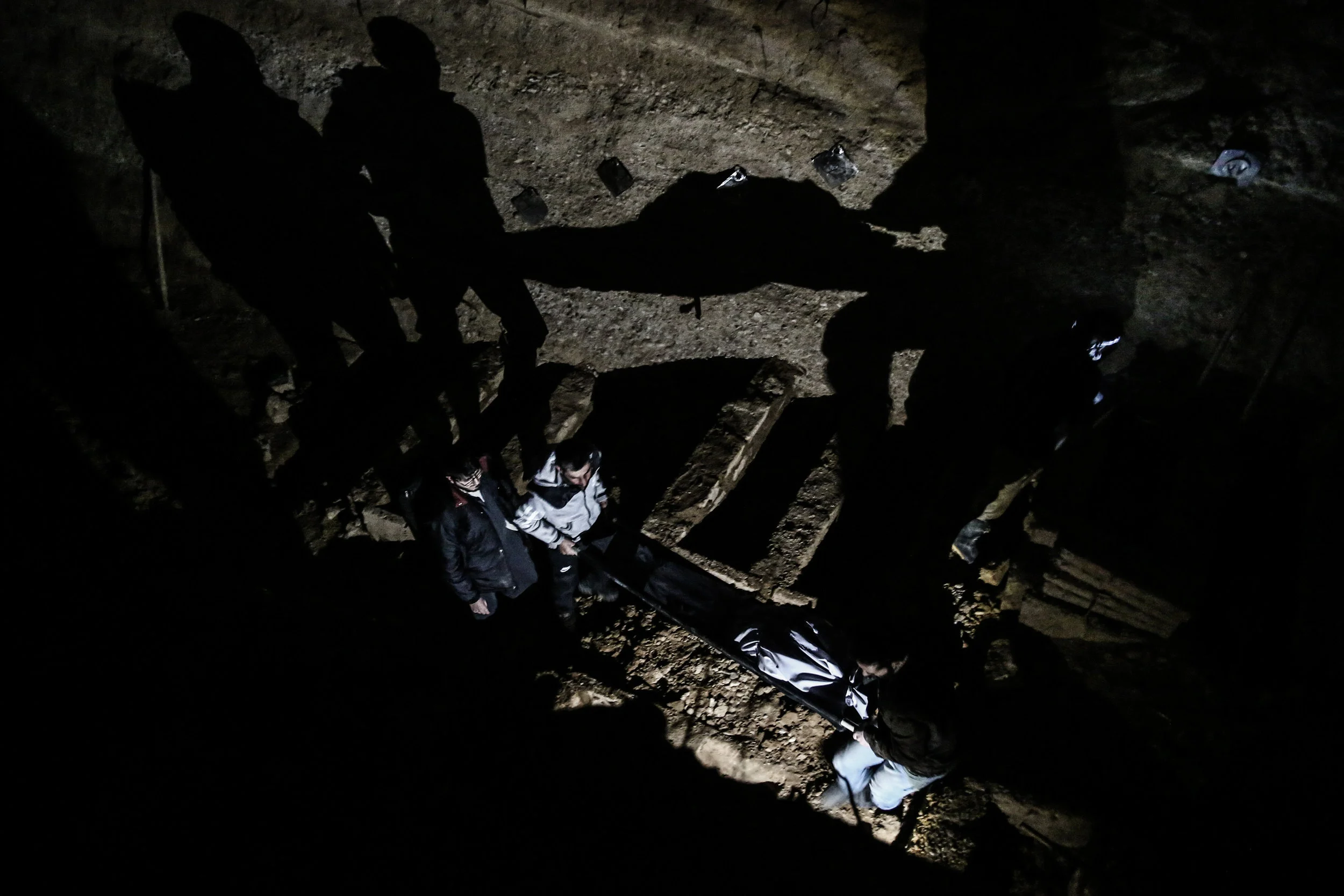 Men gather to bury the bodies of a family in the city of Douma. The family, made up of two boys, their mother and their grandmother, were killed during shelling by the Syrian government forces as they were having a picnic.