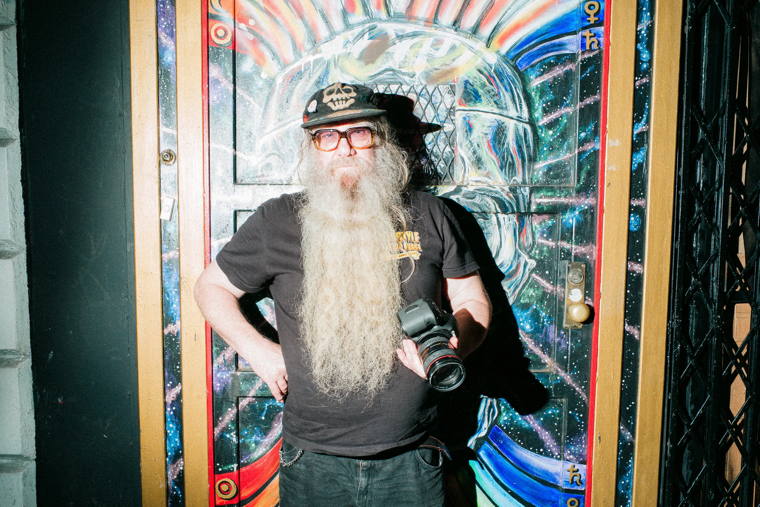  Clayton Patterson in front of his graffitied door to Outlaw Art Museum. 