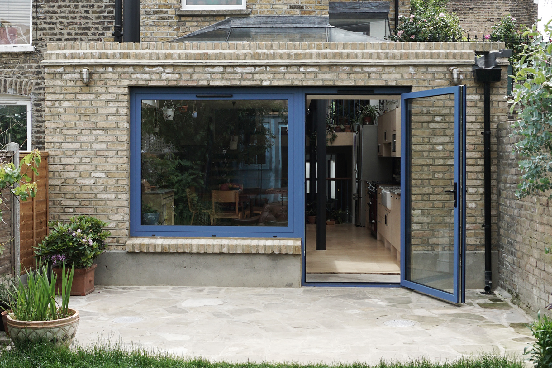  Extension with large single-leaf door to kitchen and window to wood burner area 