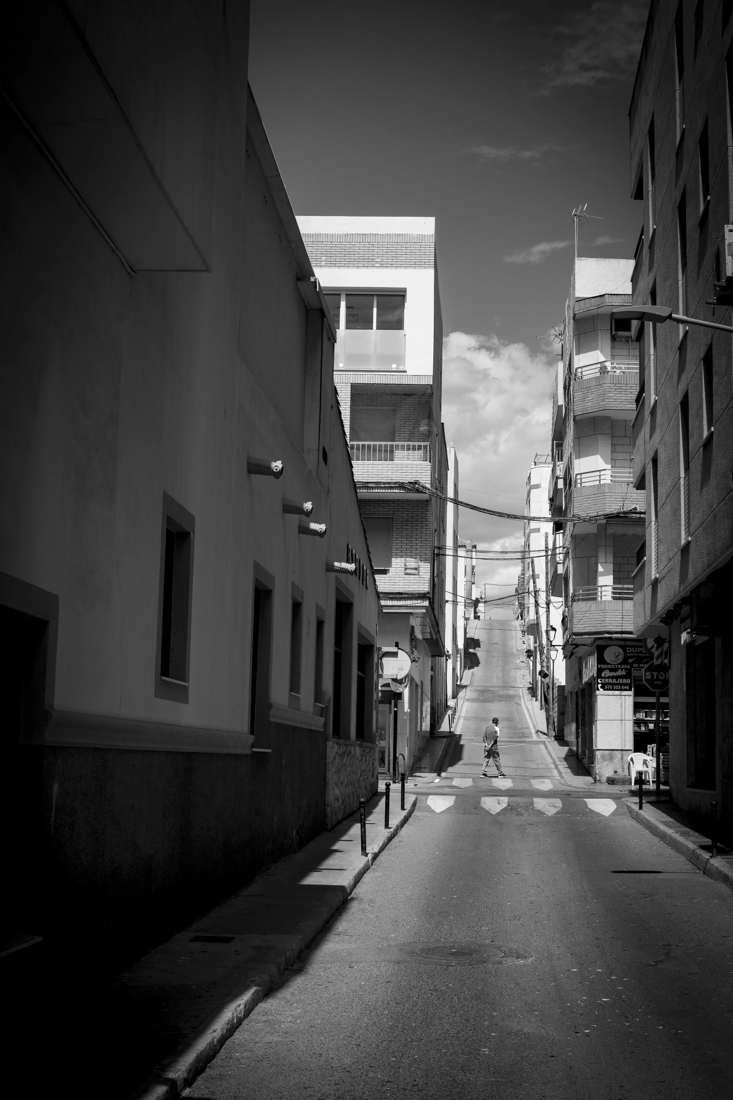 Man walks alone on hill between buildings copy.jpg