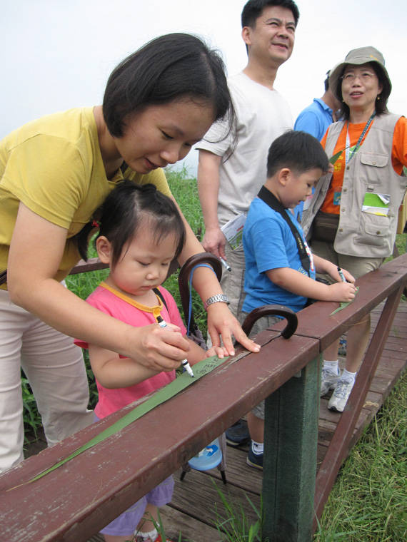  Visitors writing on reed leaves. 