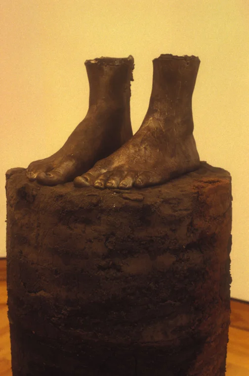 CORE SAMPLE: SELF PORTRAIT 1994 earth from every place I've lived, 1" equals 1 year, earth from Missouri, Louisiana, Illinois, Alabama, Minnesota, Maine, Missouri, Glue, life cast bronze of my feet, cylinder, 43" x 12", detail.