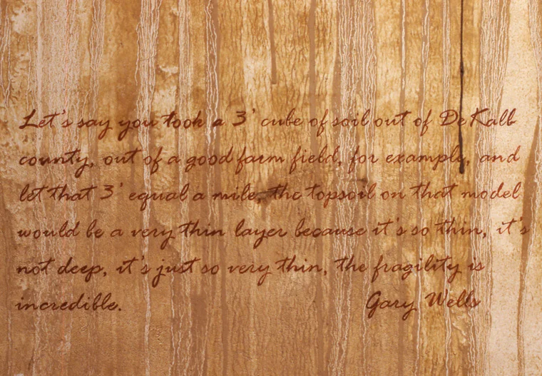 View of walls stained with local pigments and lettered with text from Gary Wells interview.